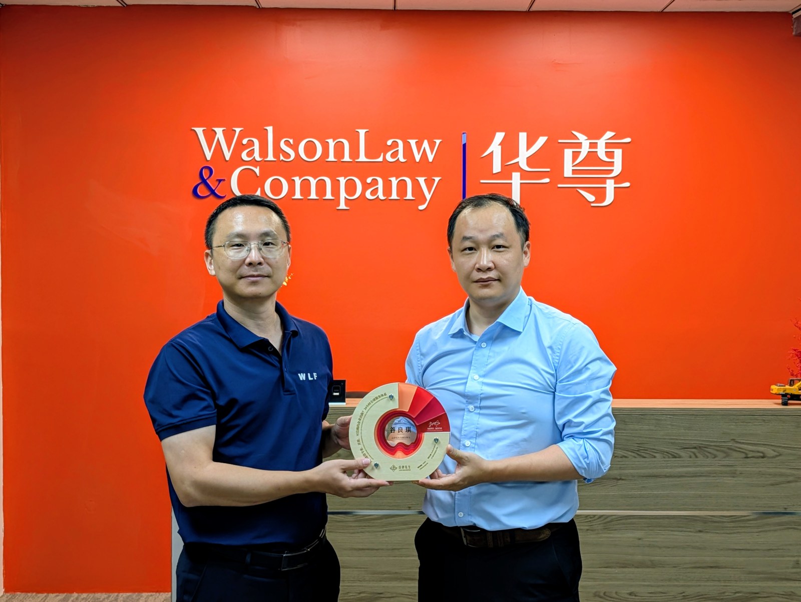 老挝中心成立期间,两位参与者手持纪念牌合影
